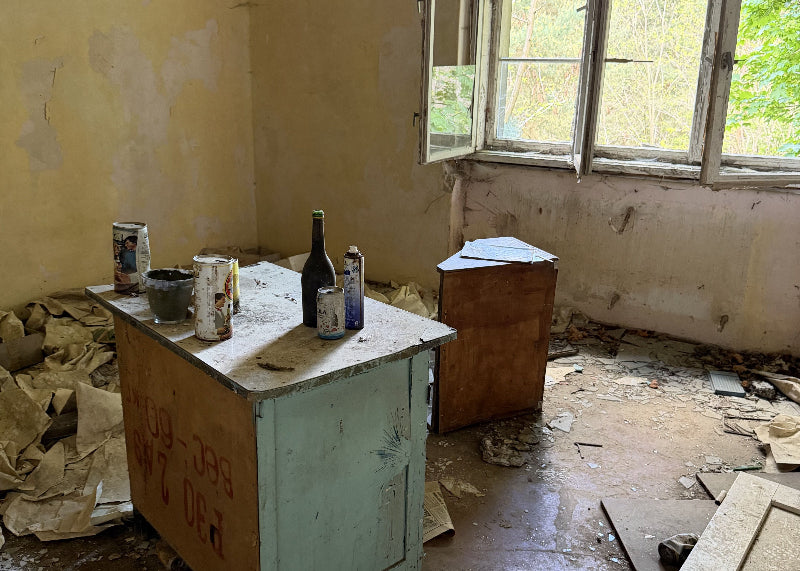 Foto von dem ehemaligen Inventar einer Küche mit kaputten Wänden und Fussboden. 