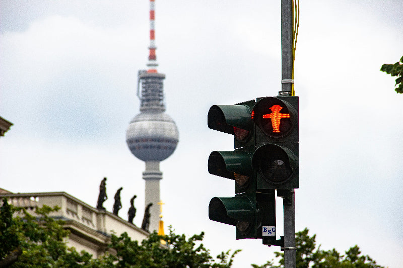 Rote Ampel mit berüchtigtem roten AMpelmännchhen in Berlin mit Fernsehturm in Hintergrund. 