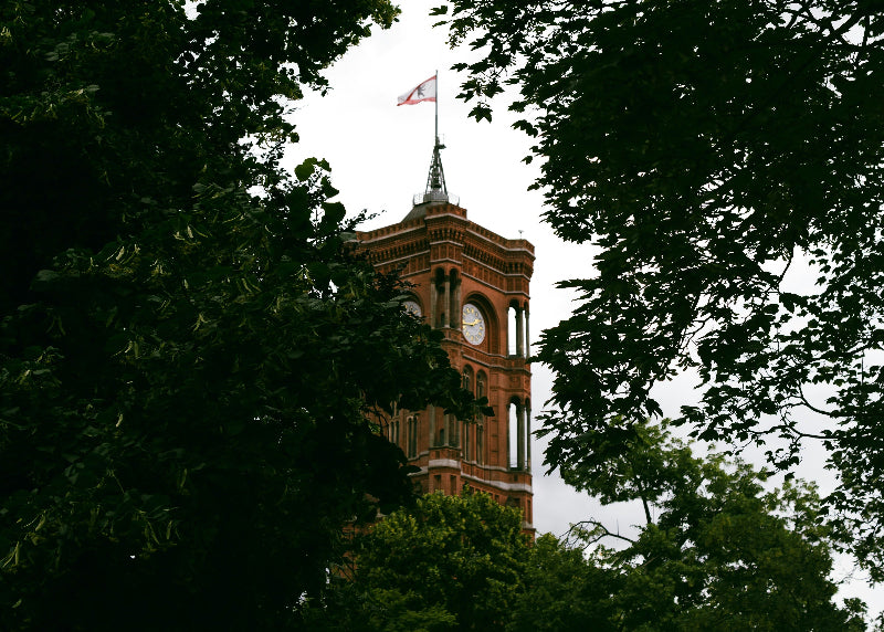 Turm des Roten Rathaus in Berlin mit Uhr und Berliner Fahne. 