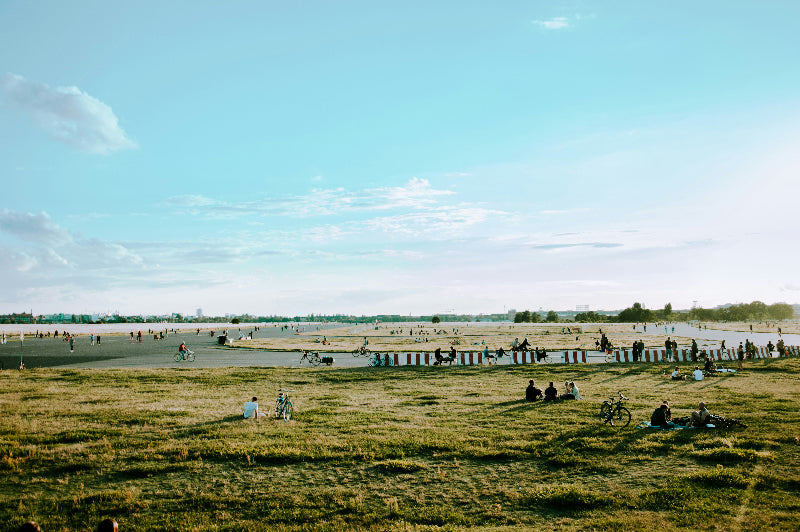 Tempelhofer Feld mit Landebahn und vielen Besuchern und grüner Wiese.