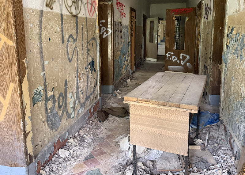 Foto von einem alten Schreibtisch und viel Graffiti in der ehemaligen Schule in Wünsdorf, Brandenburg.