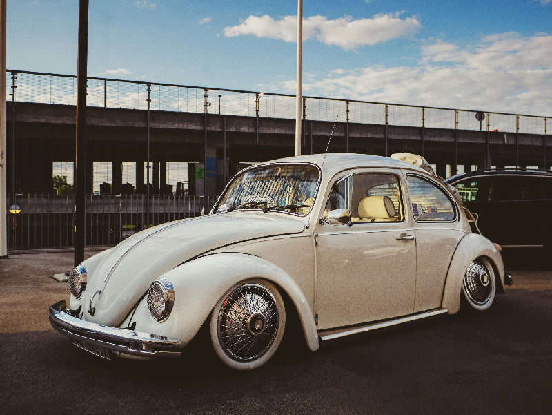 Ein gut erhaltener Oldtimer von VW vor einer Brücke in Berlin. 